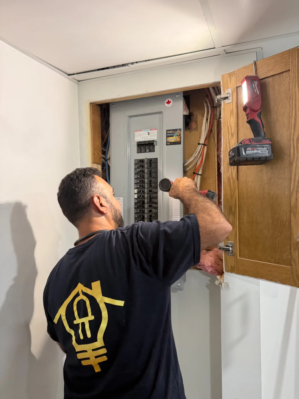 RAEM electrician working on an electrical panel